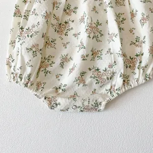 Detail of snap button closures on floral baby romper with textured jacquard fabric