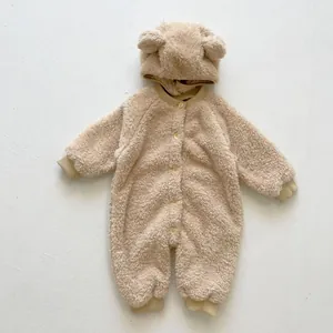 Close-up of beige fleece baby romper featuring cute bear ears on the hood and button front