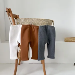 Three pairs of warm winter fleece-lined baby leggings in white, brown, and dark grey