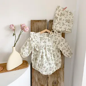 Close-up of baby floral romper set with delicate lace details and matching bonnet
