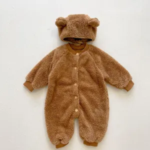 Detail of baby teddy fleece romper with bear ears and wood-texture buttons in brown