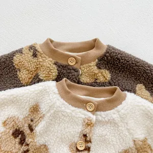 Detail of infant lamb fleece cardigans featuring bear prints and wooden buttons