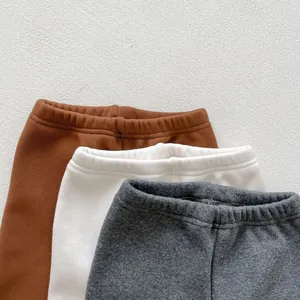 Detail of elastic waistbands on thick winter leggings for toddlers in brown, white and grey