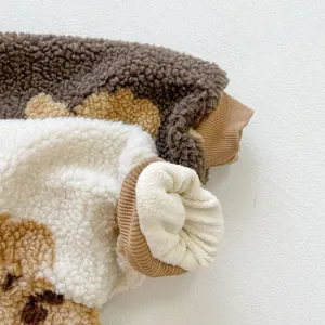 Close-up of soft lamb wool texture and cute bear print on baby winter romper
