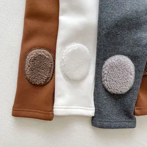 Detail of baby winter leggings featuring plush knee patches and ribbed cotton texture