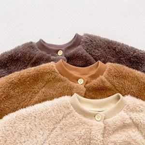 Detail of soft fleece baby jumpsuits in brown, caramel and cream with cozy texture