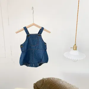Detail of dark blue denim baby bodysuit with metal buttons and snap bottom closure