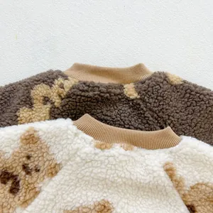 Detail of baby bear fleece jumpsuit showing textured lamb wool fabric and cute bear patterns