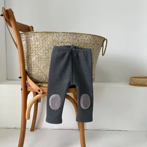 Close-up of thick winter baby leggings with plush fleece knee patches in dark grey