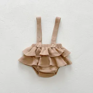 Détail du barboteuse gaufrée pour bébé avec ourlet à volants et boutons réglables