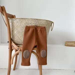 Detail of baby winter pants featuring round plush knee patches and elastic waistband