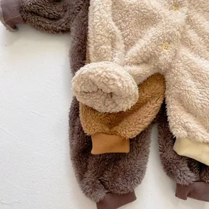 Close-up of three fleece baby rompers showing plush teddy fabric and ribbed cuffs