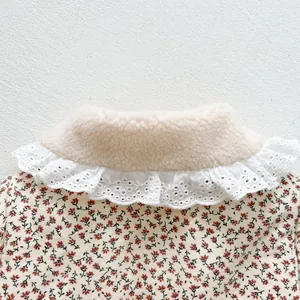 Détail d'une veste fleurie pour bébé avec doublure en laine d'agneau et col en dentelle