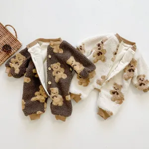 Detail of fleece baby rompers with bear print and wooden buttons for winter comfort
