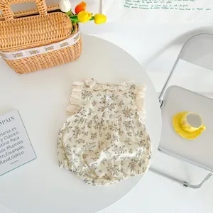 Detail of baby floral cotton romper featuring a lace collar and ruffled sleeves