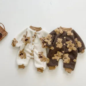 Detailed close-up of baby teddy bear print fleece rompers with natural wooden buttons