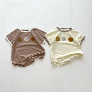 Close-up of cotton baby bodysuits with smile face prints and metal snap buttons