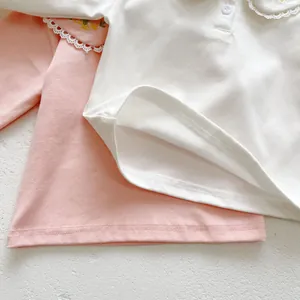Detailed view of baby cotton shirt with delicate lace collar and floral embroidery pattern