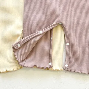 Detail of ribbed cotton baby bodysuits with snap buttons and ruffled lotus leaf edges