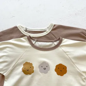 Detail view of cotton baby t-shirts with raglan sleeves and cute cartoon cloud prints