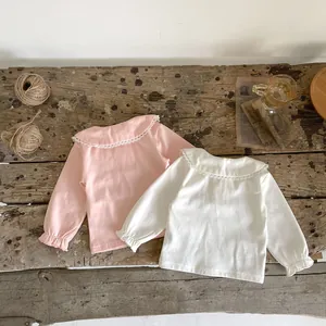 Detail of delicate lace collar and elastic ruffled cuffs on cotton long sleeve baby tops