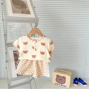 Detail of baby cotton gauze summer set featuring cartoon bear print and checkered shorts