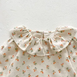 Détail d'un body fleuri pour bébé avec col à volants plissés et texture en coton doux
