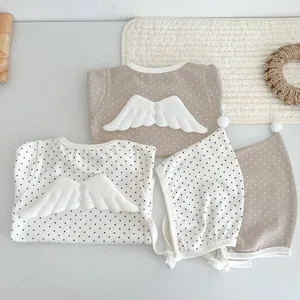 Close-up of baby romper with polka dots and soft 3D angel wings detail on the back