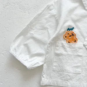 Détail d'un haut pour bébé avec broderie ours mignonne et poignets élastiqués