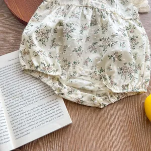 Detail of floral baby bodysuit featuring plumeti cotton fabric and snap button closure