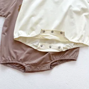 Close-up of metal snap fasteners on cotton baby bodysuit for easy diaper changes