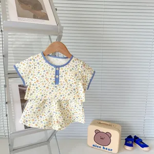 Detail of floral baby summer set featuring seersucker texture and plaid trim accents