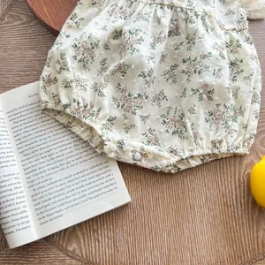 Detail of floral baby bodysuit featuring snap button closure and textured cotton fabric
