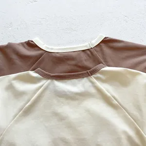 Detail of short sleeve baby bodysuit with raglan stitching and soft cotton texture