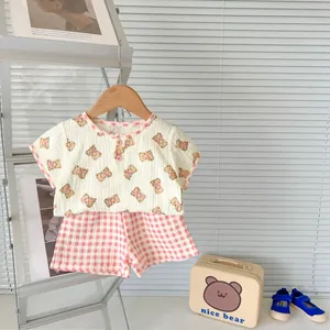 Detail of infant summer cotton set with bear print top and pink checkered shorts on hanger
