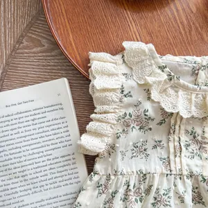 Detail of floral baby romper with lace ruffles and textured cotton fabric