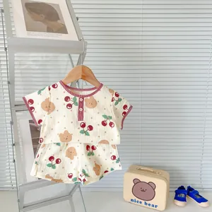 Detail of baby cotton gauze summer set featuring bear cherry print and plaid edges