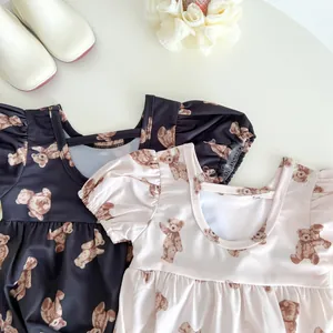 Detailed flat lay of toddler swimsuits with bubble sleeves and bear patterns