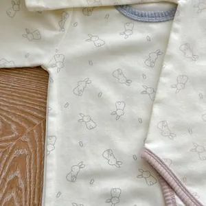 Close-up of baby bodysuit showing soft cotton fabric and cute rabbit print patterns