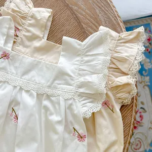 Detail of baby rompers with floral embroidery, square collar and lace flutter sleeves