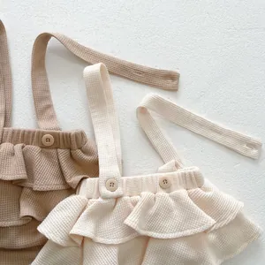 Détails du barboteuse bébé en maille gaufrée avec volants et texture de tissu doux