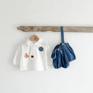 Ensemble bébé deux pièces avec chemise blanche et salopette en jean avec broderies