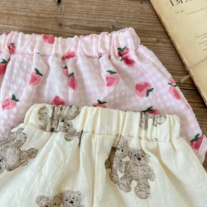 Dettaglio di pantaloncini estivi per neonati con stampe di fragole e orsetti