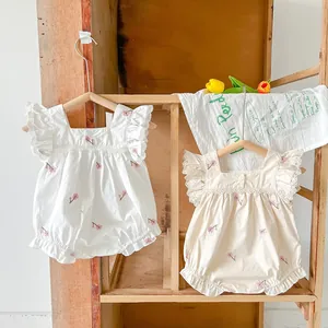 Close-up of baby romper featuring delicate floral embroidery and lace square neck detail
