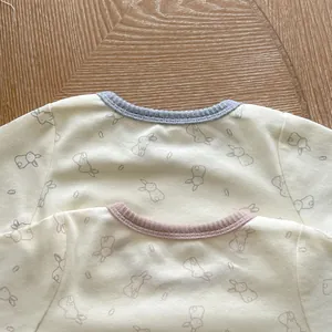 Detailed view of soft cotton baby onesies with cute rabbit patterns and ribbed necklines