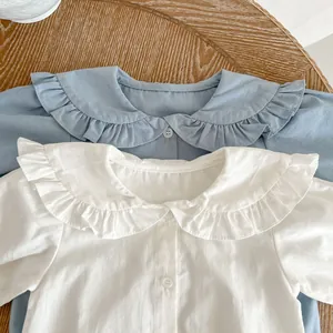 Détail d'un barboteuse bébé en coton avec col Peter Pan à volants et boutons blancs