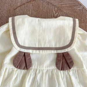 Détail du barboteuse bébé avec col marin, oreilles 3D et ruban marron élégant