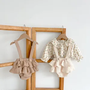 Détail du body floral pour bébé et de la salopette en maille gaufrée à volants