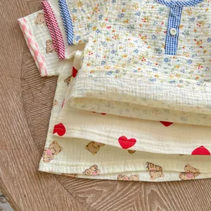 Detailed texture of muslin cotton baby sets featuring floral, bear, and heart patterns