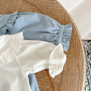 Détail de bodies bébé montrant les cols Claudine à volants et le coton doux